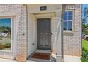 Welcoming front entryway with a dark gray door, brick facade, and a 'Home' welcome mat at 2364 Haran Dr # 35, Lithonia, GA 30058