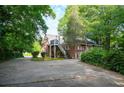 View of the back exterior featuring a parking area and lush, mature landscaping at 338 Candler Rd, Atlanta, GA 30317