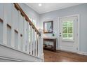 Inviting foyer with hardwood floors, white staircase, and a view of the front door at 1810 Annie Nw St, Atlanta, GA 30318
