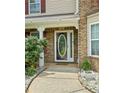 Close-up of the front door with decorative glass and brick surround, framed by a pathway and manicured landscaping at 2086 Grant Ave, Mcdonough, GA 30252