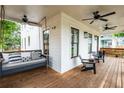 Relaxing covered porch with a swing bed, chairs, and multiple ceiling fans at 437 E Ontario Sw Ave, Atlanta, GA 30310