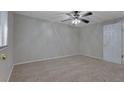 A simple bedroom featuring neutral-colored walls, carpet, and a ceiling fan with lighting at 5295 Old Trail Cir, Stone Mountain, GA 30088