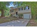 Charming split-level home with black shutters, a one-car garage, and a traditional front yard at 5295 Old Trail Cir, Stone Mountain, GA 30088