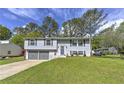 Charming two-story home with gray siding, a two-car garage, and a well-manicured front lawn at 1460 Parkmont Dr, Roswell, GA 30076