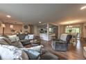 Open-concept living room features a large sectional sofa, hardwood floors, and a view into the kitchen at 1460 Parkmont Dr, Roswell, GA 30076