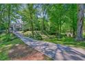 Long driveway leading to a house surrounded by beautiful trees and foliage at 2162 Brookview Nw Dr, Atlanta, GA 30318