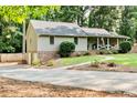 Home with a long driveway leading to a side entrance, enhanced by professional landscaping and mature trees at 3255 Sutcliffe Nw Rdg, Marietta, GA 30064
