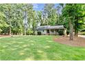 Expansive front yard featuring a well-maintained lawn and mature trees, complementing the home's idyllic setting at 3255 Sutcliffe Nw Rdg, Marietta, GA 30064
