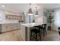 Bright kitchen featuring a central island with marble countertop, stylish lighting, and light wood floors at 2840 Alpine Rd, Atlanta, GA 30305