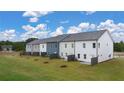 A row of newly built townhomes with varying exterior colors and well-maintained lawns under a bright, cloudy sky at 54 Leggett Dr, Villa Rica, GA 30180