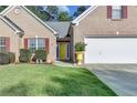 A closer look at the charming brick home with a two-car garage and bright yellow front door at 755 James Ridge Dr, Lawrenceville, GA 30045