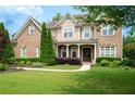 Beautiful two-story brick home with a manicured lawn and covered front porch at 440 Scott Farm Dr, Powder Springs, GA 30127