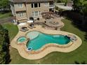 Stunning backyard oasis with custom pool, spa, stone patio, pergola, and fire pit at 440 Scott Farm Dr, Powder Springs, GA 30127