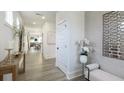 Hallway with wood floors features white trim, a console table, and artwork at 1834 Butterfly Way, Marietta, GA 30066