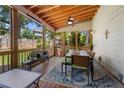 Cozy screened-in porch featuring a wood ceiling, fan, and outdoor dining furniture at 503 Bonnie Dr, Woodstock, GA 30188
