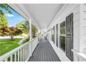 Long covered porch featuring gray decking, white railings and exterior wall, and dark window shutters at 4027 Mount Vernon Dr, Woodstock, GA 30189