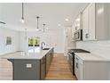 A bright kitchen with a large island, modern appliances, and stylish pendant lights at 4541 Moray Dr, Mableton, GA 30126