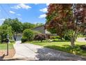 Beautiful home showcasing a lakeside view, a concrete driveway and mature trees in a well-maintained yard at 635 Stone Harbor Sw Pkwy, Marietta, GA 30060