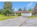 Ranch style home featuring a large two car garage, long driveway, and mature landscaping at 95 Stephens Dr, Covington, GA 30016