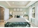 Main bedroom featuring a tray ceiling, large windows, and ensuite bathroom at 209 Maycrest Path, Tucker, GA 30084