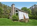 Exterior view of a home featuring a stone chimney and a lush green lawn at 2003 Greeson Rd, Dacula, GA 30019