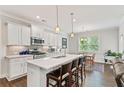 Modern kitchen with white cabinets, a large island, stainless steel appliances, and an adjacent dining area at 3219 Blackshear Dr, Marietta, GA 30060