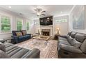Bright living room featuring a fireplace, ceiling fan, plush seating, and large windows at 3219 Blackshear Dr, Marietta, GA 30060