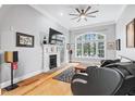 Bright living room with a large window, fireplace, hardwood floors, and modern ceiling fan at 4100 Paces Se Walk # 2304, Atlanta, GA 30339