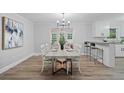 Elegant dining room with stylish lighting, a modern table, and views into the kitchen at 1131 Mayfield Dr, Decatur, GA 30033