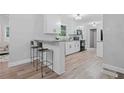 Bright kitchen featuring white cabinets, stainless steel appliances, granite countertops, and a breakfast bar at 1131 Mayfield Dr, Decatur, GA 30033