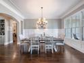 Formal dining room featuring a large window, wainscoting, and an elegant chandelier at 1963 Skybrooke Ln, Hoschton, GA 30548