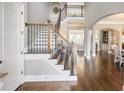 Grand foyer with hardwood floors, staircase with iron spindles, and views into adjacent living spaces at 1963 Skybrooke Ln, Hoschton, GA 30548