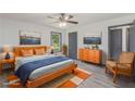 Bright bedroom featuring a ceiling fan, stylish decor, artwork and a comfortable bed at 5406 Jamestowne Dr, Powder Springs, GA 30127