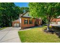 Side view of a beautiful brick home with a three car garage and mature landscaping at 1059 Verbena Way, Auburn, GA 30011