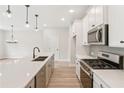 A modern kitchen with stainless steel appliances, a large island, and pendant lighting at 4527 Moray Dr, Mableton, GA 30126