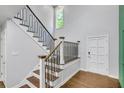 Open staircase with hardwood steps, metal railing, and bright natural light at 615 Nw Mark Trail Nw Ct, Atlanta, GA 30328