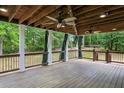 Spacious covered back deck with ceiling fans, wooden floors, and a peaceful outdoor ambiance at 300 Summer Pond Trl, Lawrenceville, GA 30046