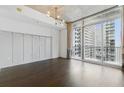 Spacious living room featuring dark hardwood floors and oversized windows with city views at 44 Peachtree Nw Pl # 1728, Atlanta, GA 30309