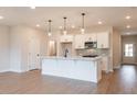 Open concept kitchen featuring an island with pendant lighting, stainless steel appliances, and hardwood floors at 4523 Moray Dr, Mableton, GA 30126