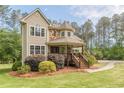 Charming two-story home featuring a stone turret and inviting front porch at 830 Hightower Trl, Oxford, GA 30054