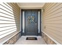 Stylish front door with sidelights, decorative wreath, and welcome mat, creating a warm entrance at 3134 Milloak Ct, Buford, GA 30519