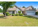 Beautiful single-story home with a well-maintained lawn, landscaped bushes, and an attached two-car garage at 3134 Milloak Ct, Buford, GA 30519