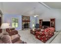 Spacious living room with a stone fireplace, high ceilings, and a ceiling fan at 3739 Lake Carlton Rd, Loganville, GA 30052