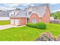 Beautiful two-story brick home with a two-car garage, green lawn, and mature landscaping at 1016 E Bay Springs Dr, Villa Rica, GA 30180
