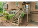 Inviting front entrance with wooden stairs and railing, stone and wood siding and lush landscaping at 1359 Cedar Park Pl, Stone Mountain, GA 30083