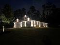 Exterior home view with elegant outdoor lighting showcasing architectural details, enhancing curb appeal in the dark at 426 Samara Ct, Fairburn, GA 30213