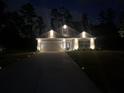 Inviting single-story home with stone accents, a well-lit driveway, and manicured landscaping at nighttime at 426 Samara Ct, Fairburn, GA 30213
