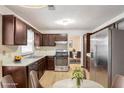 A spacious kitchen with stainless steel appliances, wood cabinets, and an adjoining dining area with flowers at 615 Barrington Way, Roswell, GA 30076
