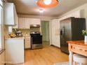 Bright kitchen showcasing stainless steel appliances, white cabinets, and modern wooden floors at 615 Barrington Way, Roswell, GA 30076