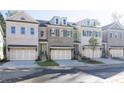 Row of modern townhomes with neutral brick, multi-car garages, dormer windows, and well-manicured landscaping at 2270 Siskin Square Rd # 91, Duluth, GA 30096
